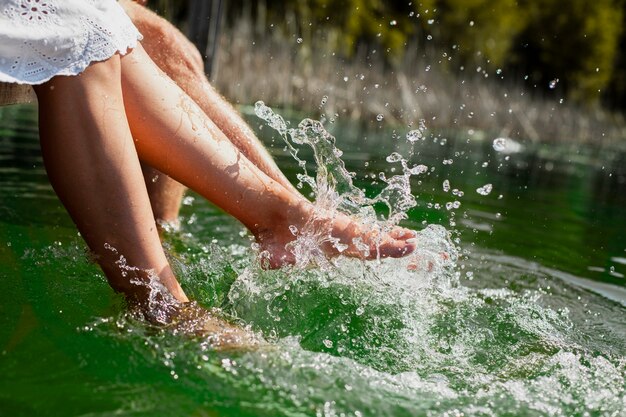 Pareja jugando con los pies en el agua