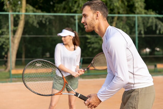 Pareja jugando tenis en dúo