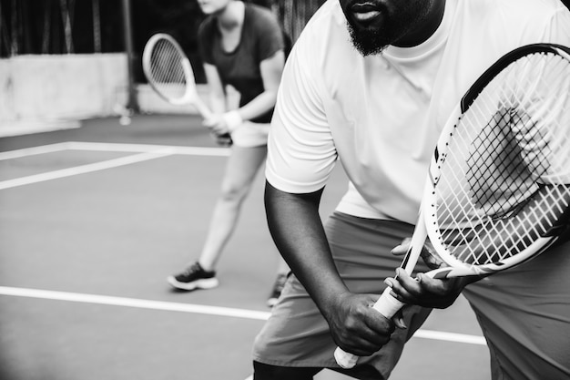 Foto gratuita pareja jugando tenis en equipo