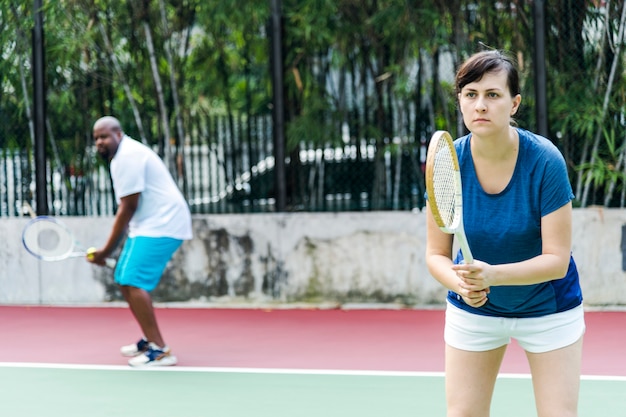 Pareja jugando tenis en equipo