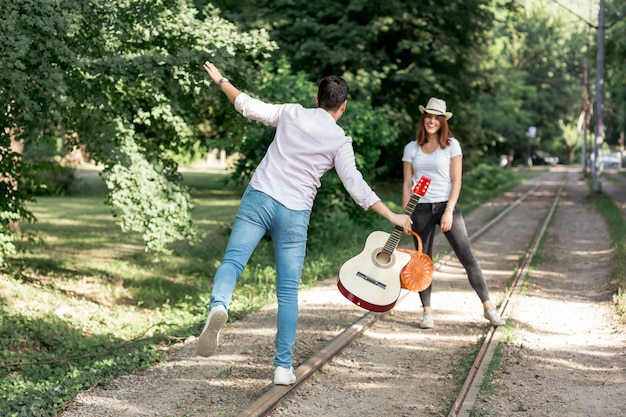 Pareja juguetona caminando en un ferrocarril