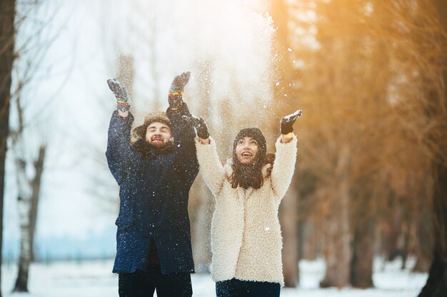 Pareja juguetona disfrutando la nieve