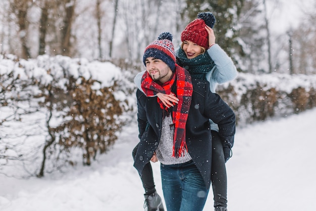 Pareja juguetona divirtiéndose en el parque de invierno