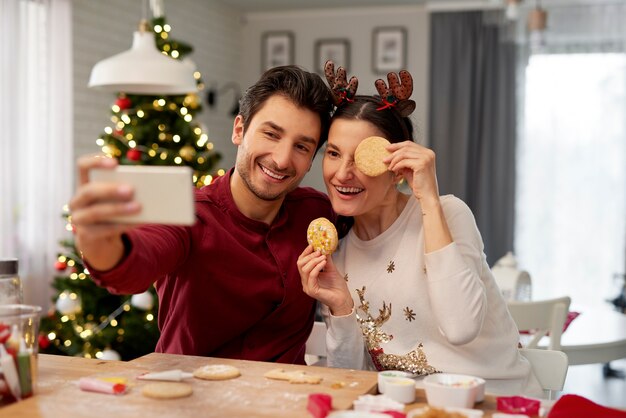 Pareja juguetona haciendo un selfie en Navidad