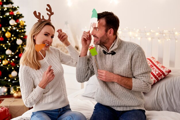 Pareja juguetona en máscaras de Navidad