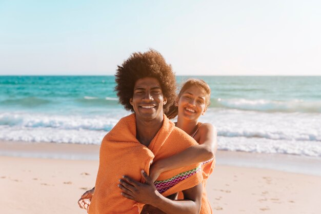 Pareja juguetona multiétnica a orilla del mar