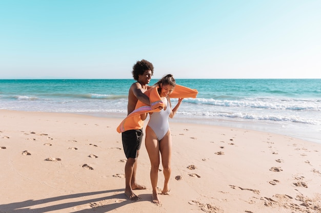 Pareja juguetona multiétnica en la playa