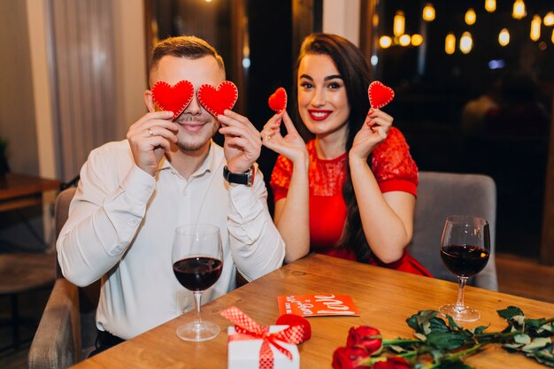 Foto gratuita pareja juguetona posando con corazones