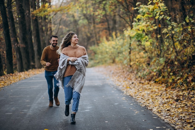 Pareja juntos en el parque cubierto de manta