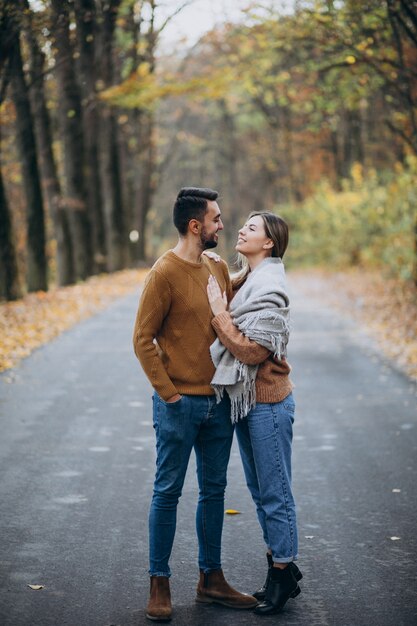 Pareja juntos en el parque cubierto de manta