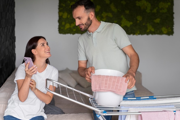 Pareja lavando la ropa juntos en casa