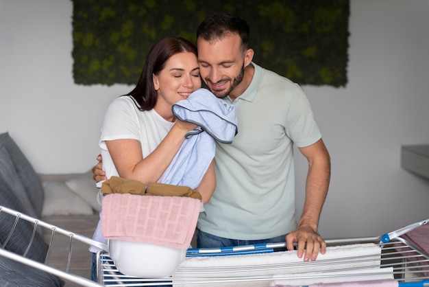 Pareja lavando la ropa juntos en casa