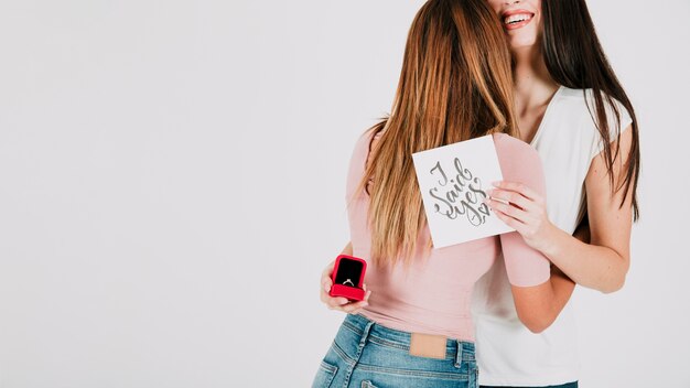 Pareja de lesbianas con anillo abrazando