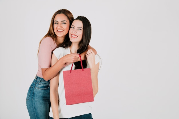 Foto gratuita pareja de lesbianas con bolsa de papel abrazando