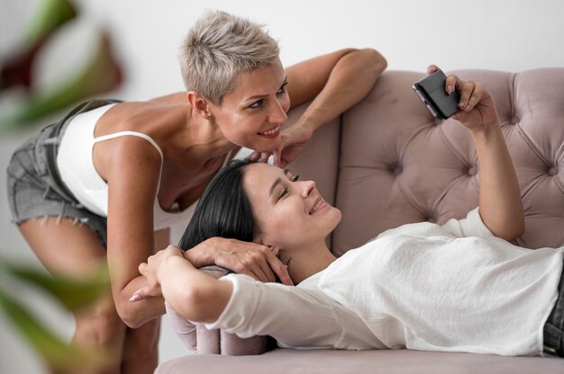 Pareja de lesbianas en casa tomando selfie