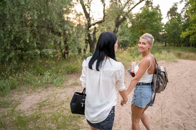 Pareja de lesbianas cogidos de la mano al aire libre