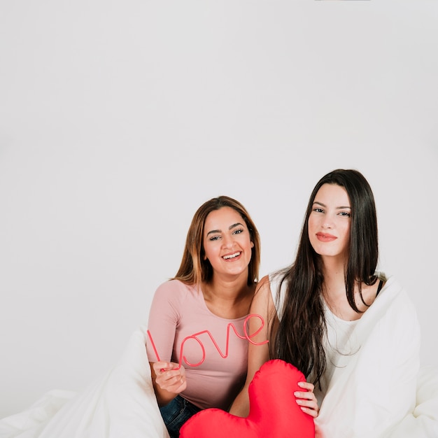 Foto gratuita pareja de lesbianas con corazón y palabra de amor