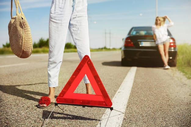 Pareja de lesbianas jóvenes que van de viaje de vacaciones en el coche en un día soleado