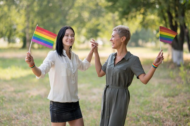 Pareja de lesbianas en el parque con banderas