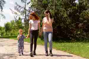 Foto gratuita pareja de lesbianas pasar tiempo con su hijo en el parque