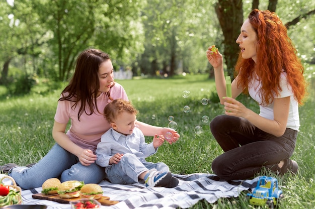 Foto gratuita pareja de lesbianas pasar tiempo con su hijo