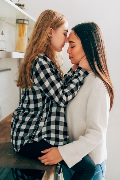 Pareja de lesbianas de pie y abrazando