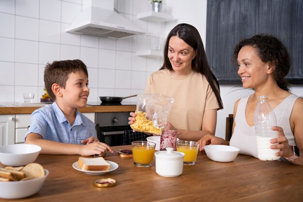 Pareja de lesbianas con su hijo desayunando