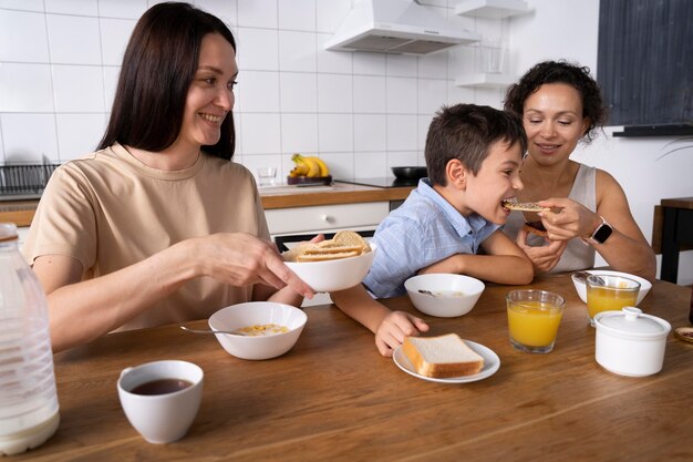 Pareja de lesbianas con su hijo desayunando