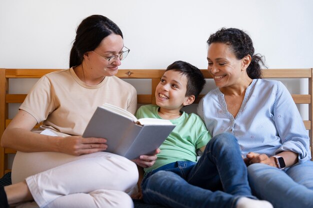 Pareja de lesbianas con su hijo leyendo juntos