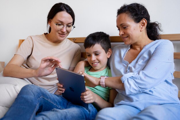 Pareja de lesbianas con su hijo mirando una tableta