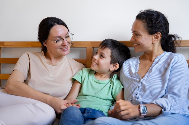 Foto gratuita pareja de lesbianas con su hijo pasar tiempo juntos en casa