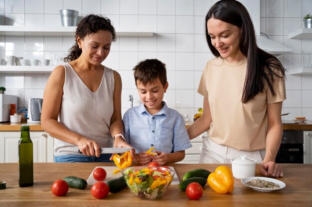 Pareja de lesbianas con su hijo preparando comida