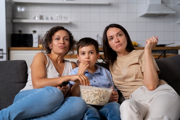 Pareja de lesbianas con su hijo viendo una película