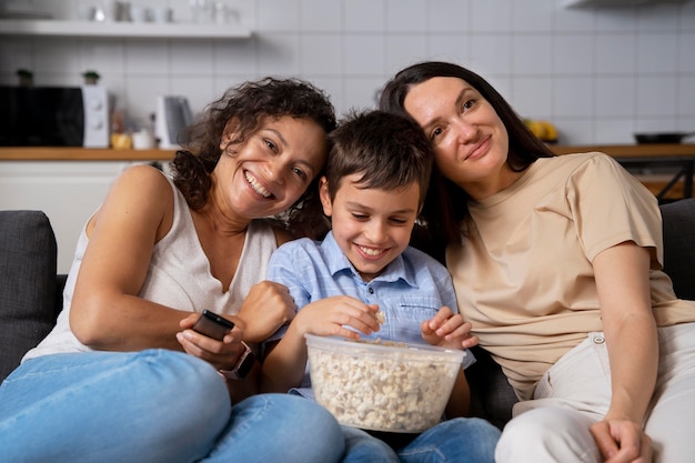 Pareja de lesbianas con su hijo viendo una película