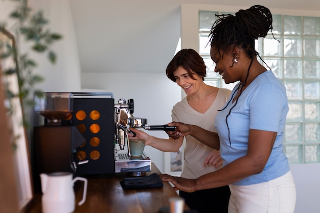 Pareja de lesbianas de tiro medio haciendo café