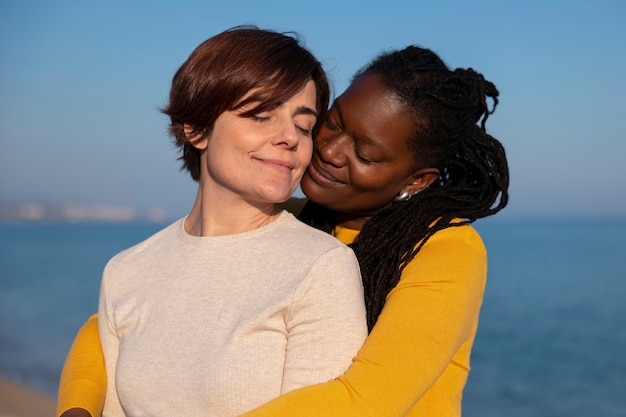 Pareja de lesbianas de tiro medio en la playa