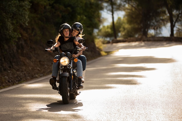 Foto gratuita pareja de lesbianas en un viaje por carretera en moto