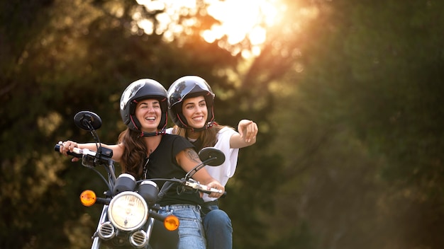 Foto gratuita pareja de lesbianas en un viaje por carretera en moto