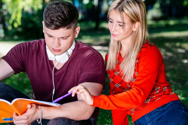 Pareja leyendo del cuaderno en el parque