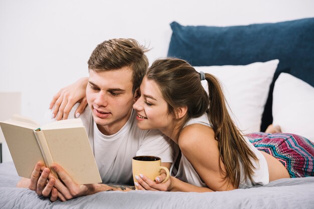 Pareja leyendo libro en cama