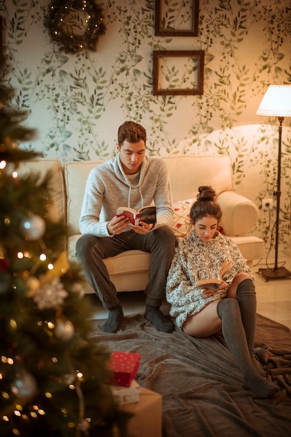 Pareja leyendo libros en casa