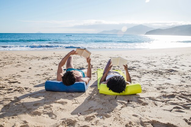 Pareja con libros en la playa