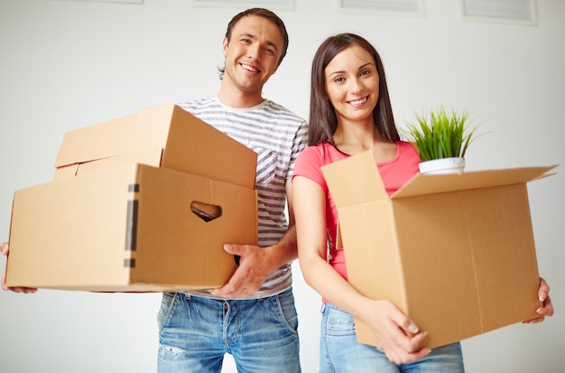 Pareja llevando cajas