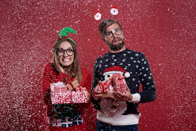 Pareja llevando un montón de regalos de Navidad