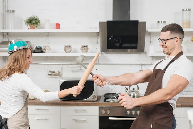 Pareja luchando de juego en la cocina