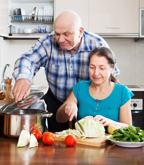 pareja madura cocinando juntos