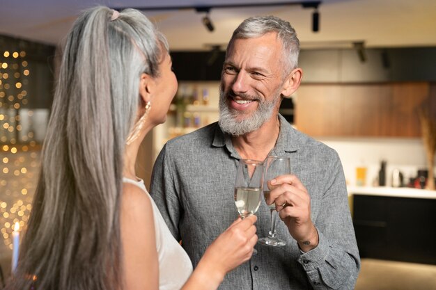 Pareja madura disfrutando de unas copas en la fiesta de año nuevo