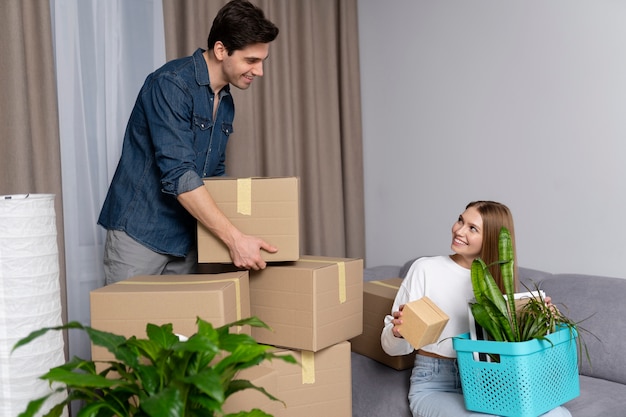 Pareja manejando cajas de pertenencias después de mudarse a una casa nueva