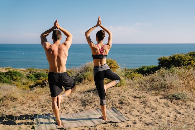 Foto gratuita pareja manteniendo el equilibrio en la playa