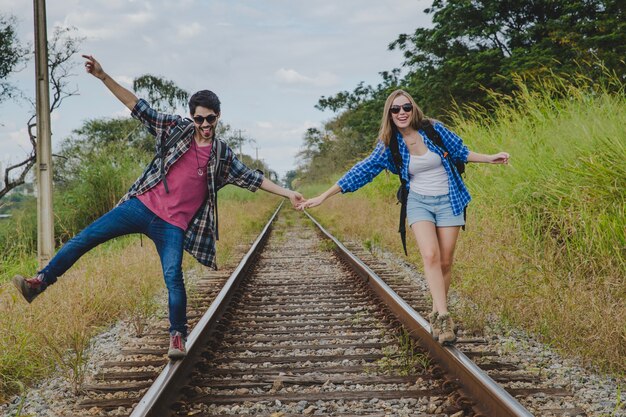 Pareja manteniendo el equilibrio en vías de tren